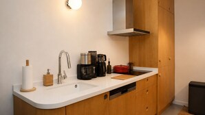 A modern kitchen with a white countertop, stainless steel appliances, and wooden cabinets. - Ayvalık Center Modern Detached House in the City Center (Ayvalık)
