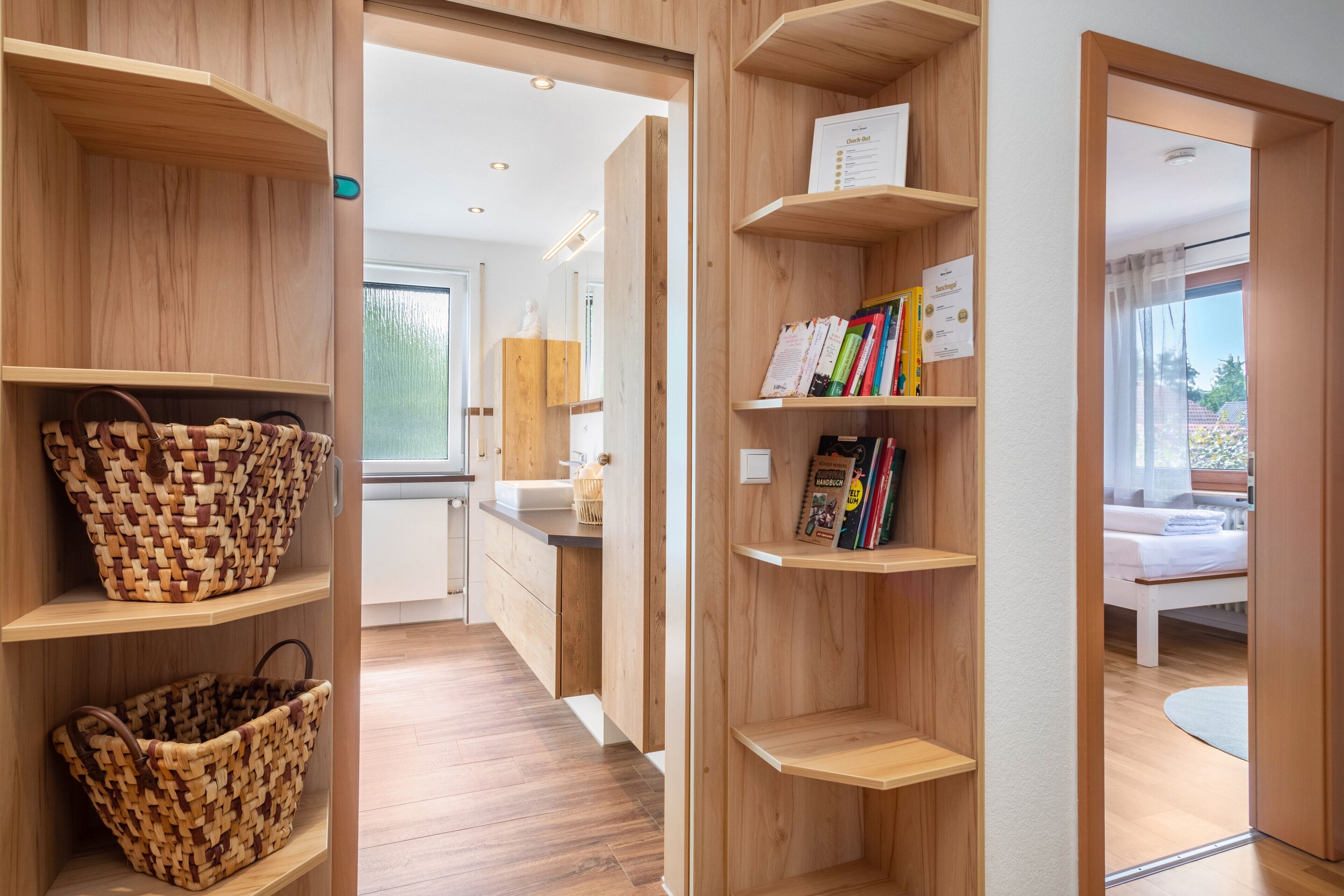 A modern interior with wooden shelving, a woven basket, and a glimpse of a bed.