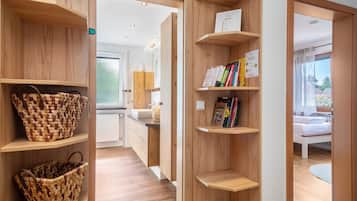 A modern interior with wooden shelving, a woven basket, and a glimpse of a bed.