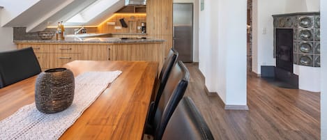 Una cocina moderna con encimera de madera, horno empotrado y refrigerador de acero inoxidable.