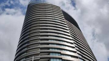 A tall, cylindrical building with horizontal lines of windows and balconies.