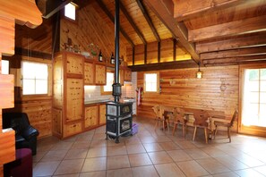 A wooden cabin interior with a kitchen, dining area, and a fireplace. - Chalet Nid d Aigle - 6 personnes - Farquesses (Les Haudères)