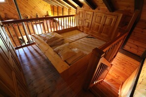 A wooden cabin interior with a loft bedroom, a staircase, and a wooden railing. - Chalet Nid d Aigle - 6 personnes - Farquesses (Les Haudères)