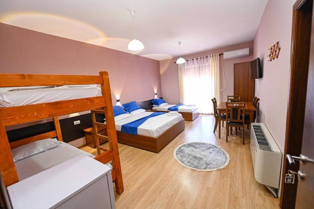 Un dormitorio con literas, un escritorio, una silla, un televisor y un aire acondicionado.