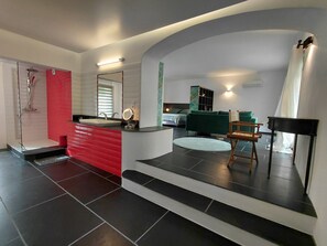 A modern bathroom with a red vanity, a shower, and a mirror. - Charmant appartement de caractère de 90 mq dans ancienne maison en pierres (Saint-Paulet-de-Caisson)