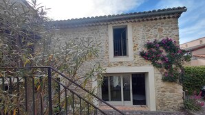 Una casa de piedra con techo de tejas, una ventana y una puerta.