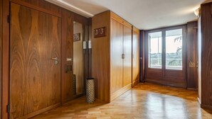 Un pasillo con armarios de madera, un basurero y una ventana con vistas.