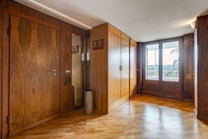 A hallway with wooden wardrobes, a trash bin, and a window with a view. - BDC - The Roman Cottage! Free parking! (Rome)
