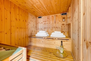 A wooden sauna room with benches, towels, a bottle, and glasses. - BDC - The Roman Cottage! Free parking! (Rome)