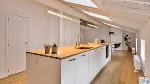 A modern kitchen with a wooden countertop, white cabinets, and a skylight. - 3 bedrooms apartment + private parking in Liege historical area (Liège)