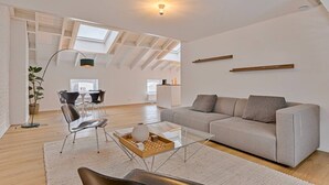 A spacious living area with a high ceiling, skylights, a sofa, a coffee table, and a dining area with chairs. - 3 bedrooms apartment + private parking in Liege historical area (Liège)