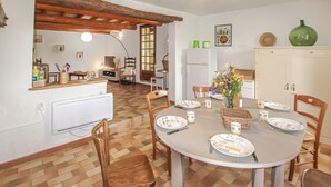 Un comedor con una mesa redonda, sillas y un armario blanco.
