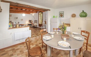 Ein Essbereich mit einem runden Tisch, Stühlen und einem weißen Schrank.