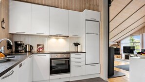 A modern kitchen with white cabinets, a built-in oven, and a coffee maker. - Amazing home in Middelfart with WiFi (Middelfart)