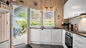 A modern kitchen with white cabinets, a dishwasher, and a coffee maker. - Amazing home in Middelfart with WiFi (Middelfart)