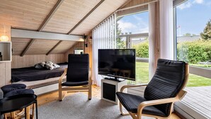 A cozy cabin with a bed, a TV, and two chairs. - Amazing home in Middelfart with WiFi (Middelfart)
