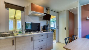 A modern kitchen with a gas stove, sink, and cabinets. - Bungalow with Private Pool, Private Terrace, and Air Conditioning (Agde)