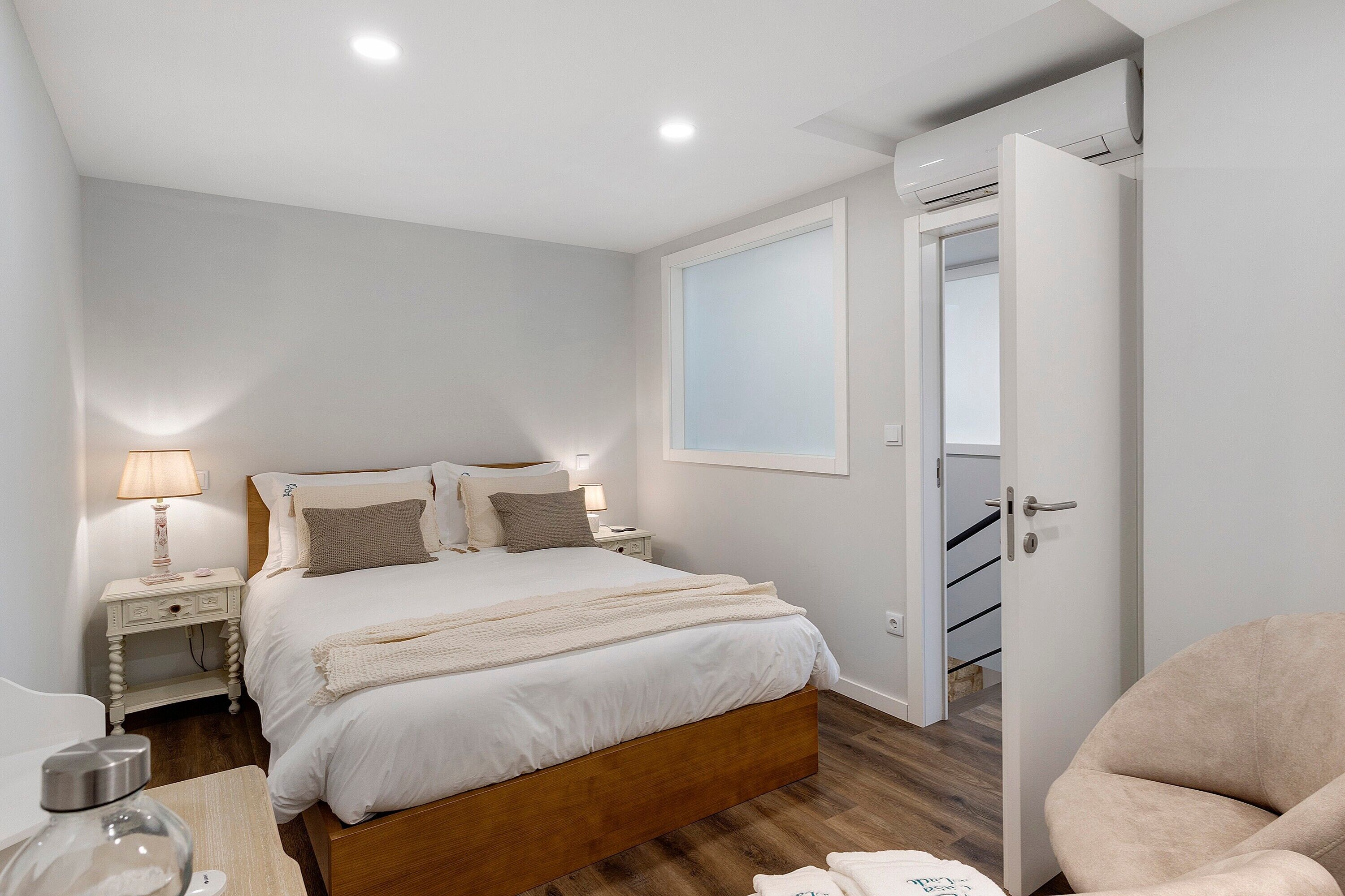 Une chambre à coucher avec un lit en bois, des tables de chevet, une lampe et une chaise.