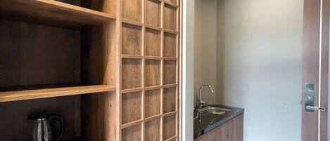 A modern kitchen with wooden cabinetry, a built-in coffee maker, and a stainless steel sink.