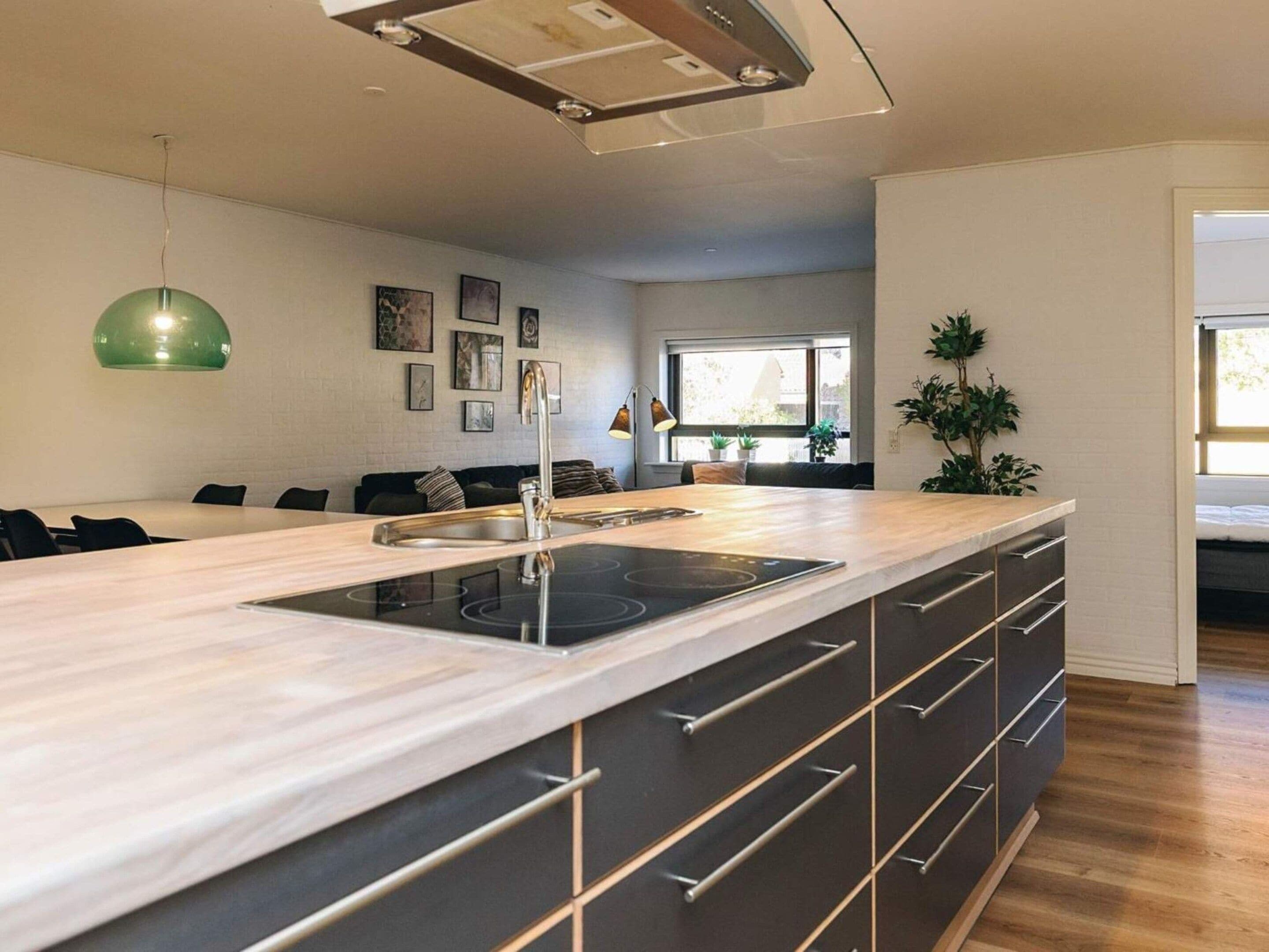 Une cuisine moderne dotée d’un îlot central, d’appareils électroménagers intégrés et d’un coin repas avec un canapé.