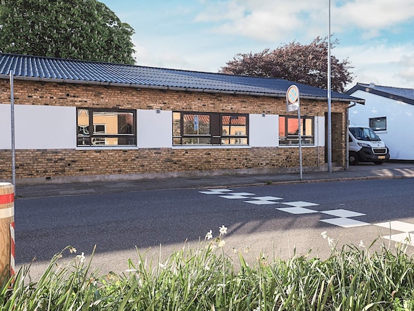 A building with a brick facade, large windows, and a parking area. - 4 Star Holiday Home in Skagen (Skagen)