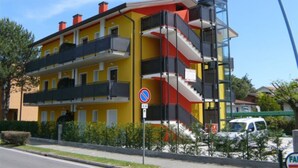 A multi-story building with balconies, a no parking sign, and a street view. - Comfortable vacation retreat in a central area (Bibione)