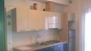 A kitchen with cabinets, a sink, and a refrigerator. - Comfortable vacation retreat in a central area (Bibione)