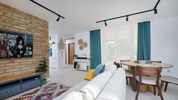 A modern living room with a sofa, TV, and dining area. - Perfect 2-bedroom lodge with AC in peaceful Balatonmáriafürdő (Balatonmáriafürdő)