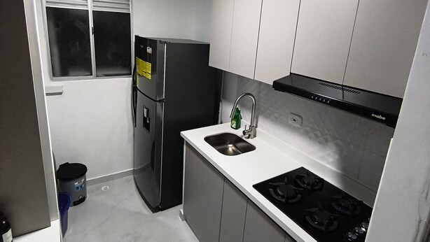 A compact kitchen with a refrigerator, stove, sink, and cabinets. - Your Home in Barranquilla (Barranquilla)