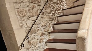 A staircase with stone walls and wooden steps. - Meublé de tourisme classé 3 étoiles (Fontvieille)