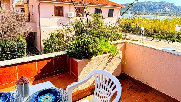 Ein Balkon mit Esstisch, Stuhl und Blick auf Gebäude und Berge.