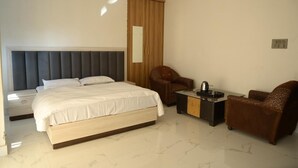 A bedroom with a bed, a nightstand, a chair, a small table, and a wardrobe. - Hotel Deep Khirsu (Khirsu)