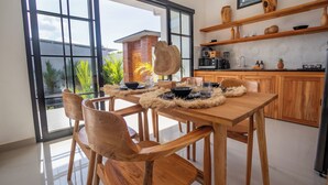 Una cocina moderna con armarios de madera, un ventanal grande y un comedor con mesa y sillas de madera.
