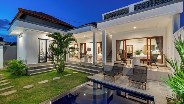 Una casa moderna con piscina, mobiliario de exterior y una escalera que lleva a la entrada.