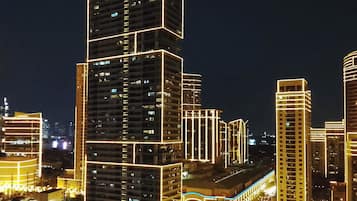 Une vue nocturne d’une ville, avec des gratte-ciel illuminés.