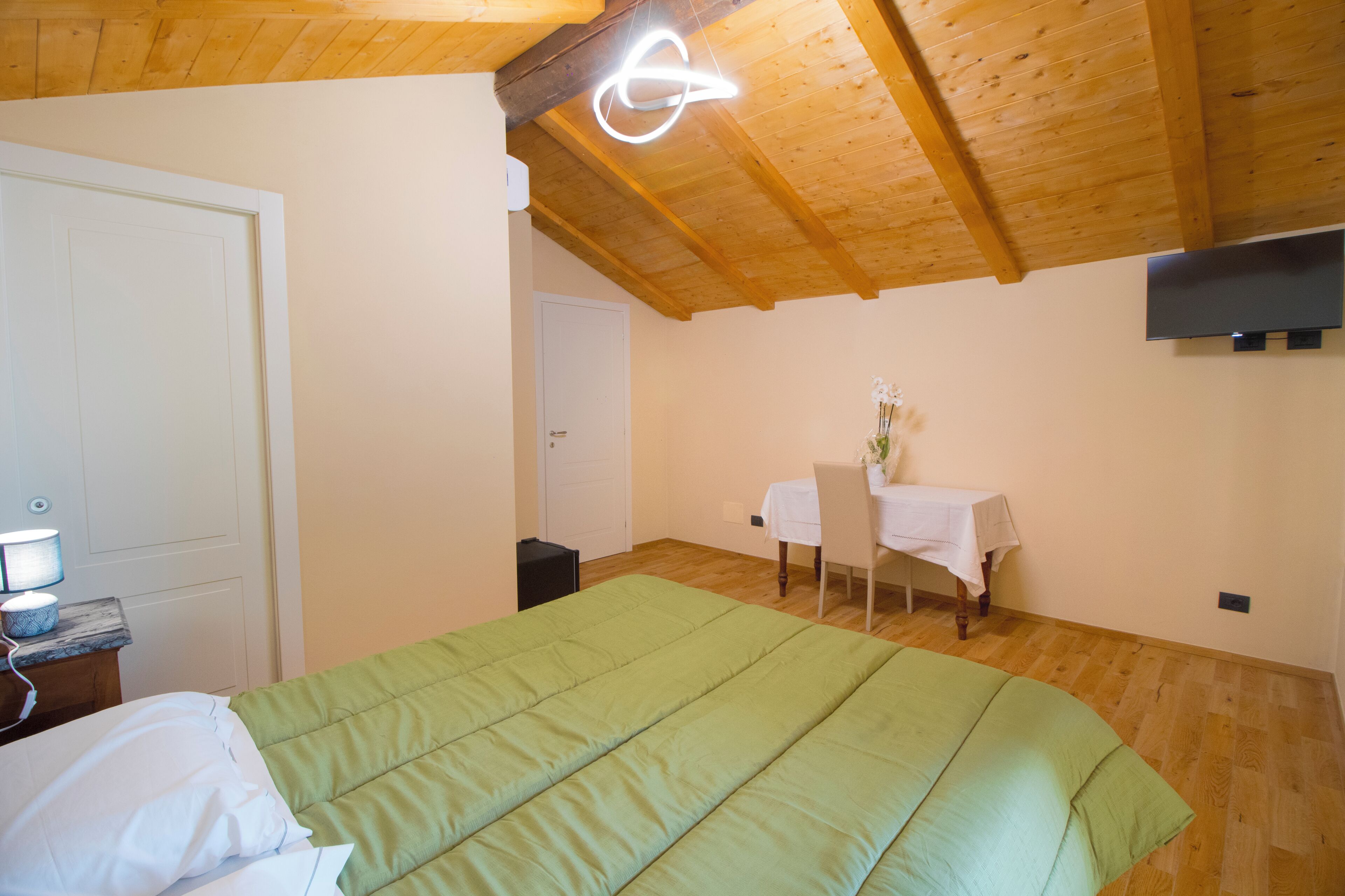 Un dormitorio con una cama, un escritorio, una silla, una mesa y un televisor.