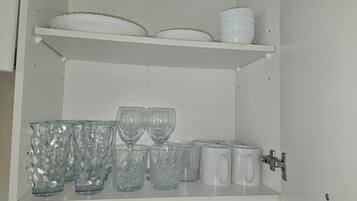 Un armario con estantes que contienen diferentes vasos y vajilla.