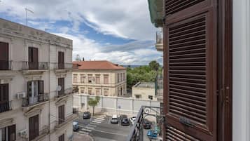 A street view with buildings, a clear sky, and parked cars.