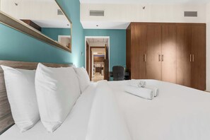 Ein Hotelzimmer mit Bett, einem Holzschrank, einem Spiegel und Blick auf den Flur.