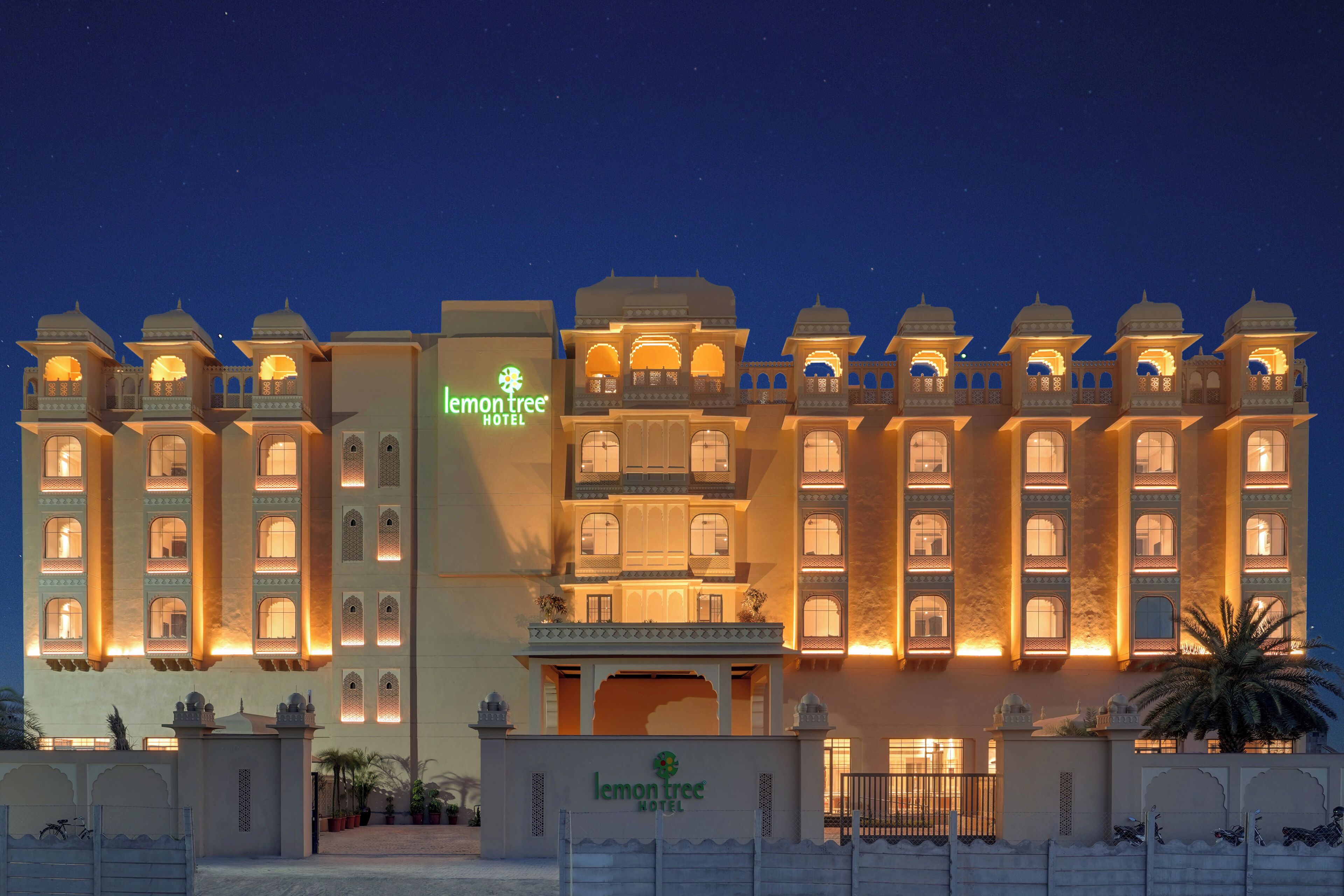 A multi-story hotel with traditional architecture, a prominent sign, and a well-lit entrance.