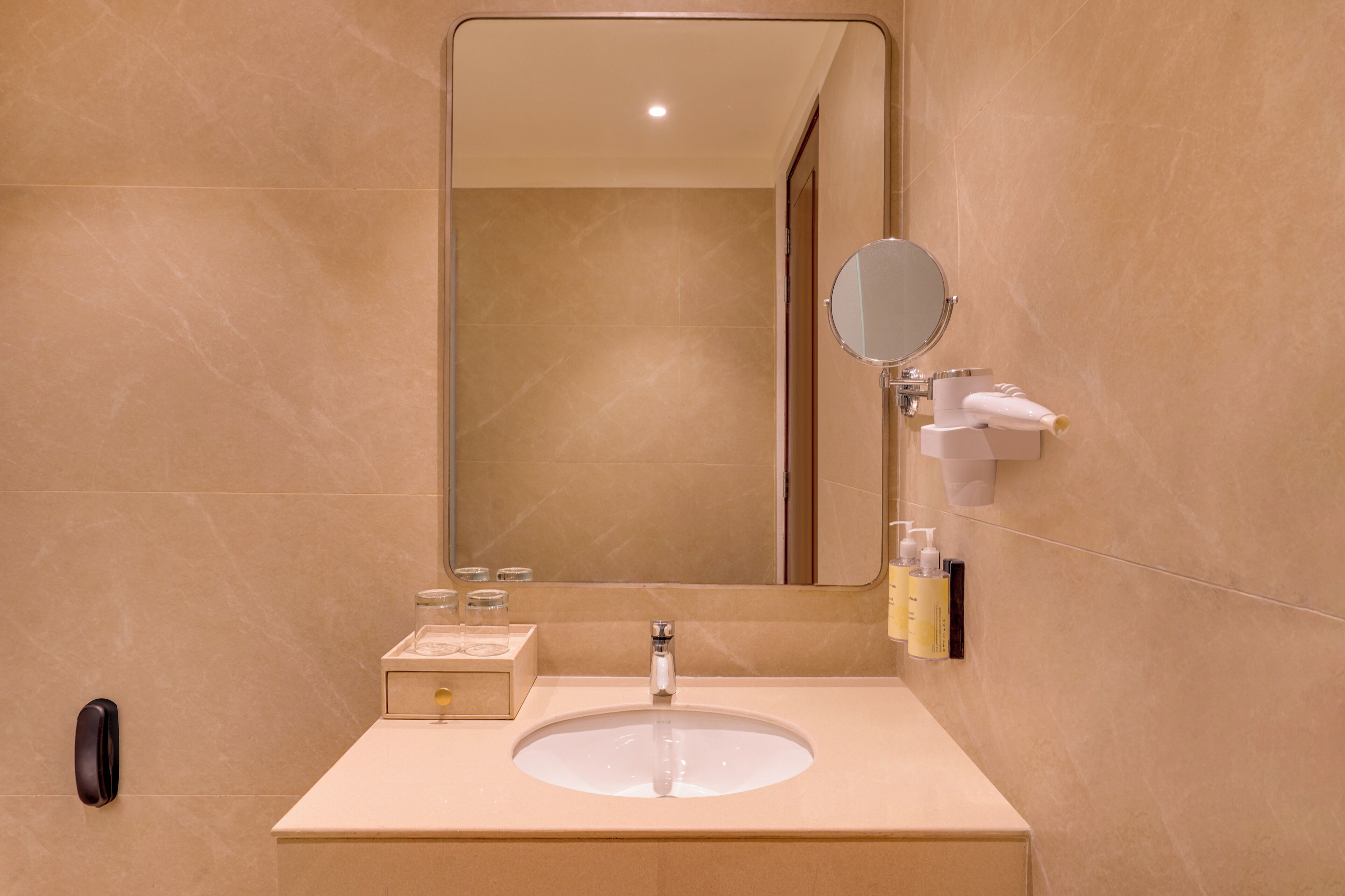 A bathroom with a sink, mirror, and toiletries.