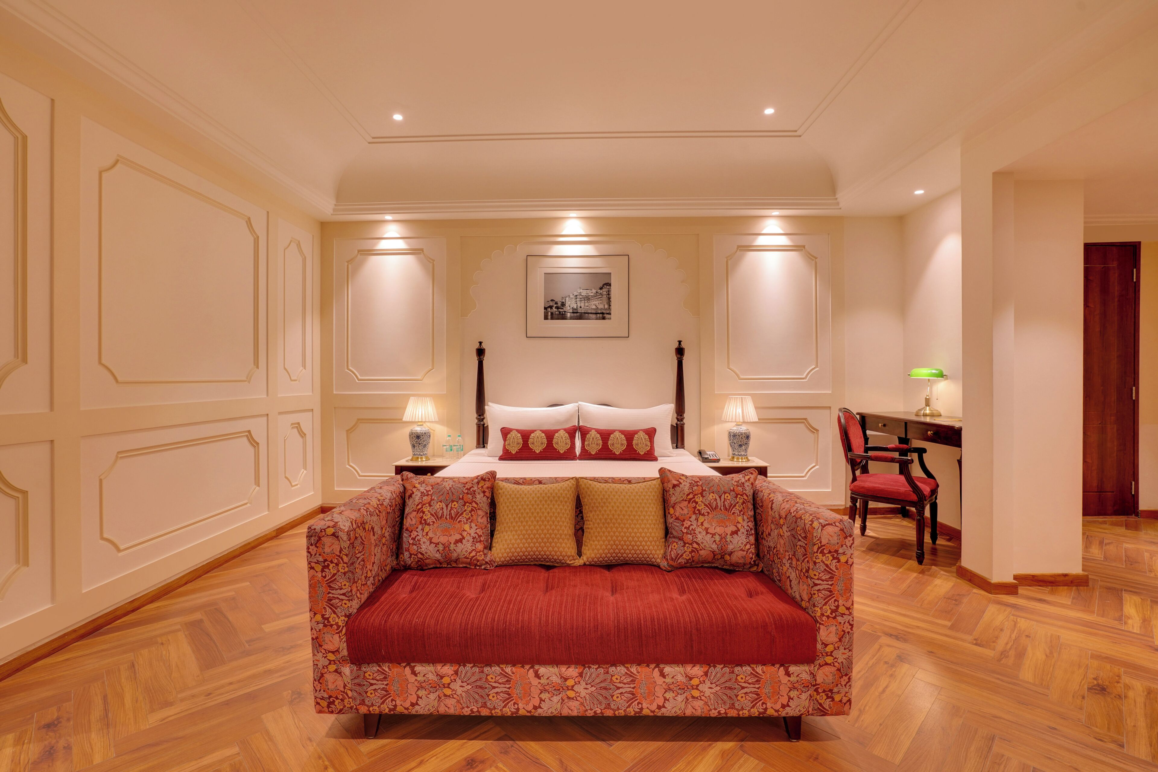 A bedroom with a large bed, a desk, and a chair.