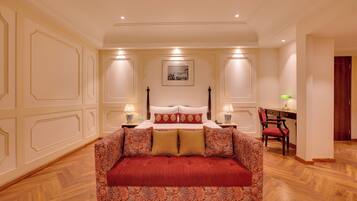 A bedroom with a large bed, a desk, and a chair.