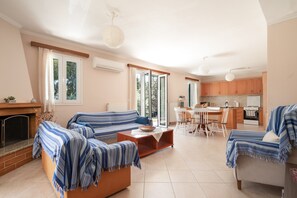 A spacious living room with a sofa set, a coffee table, and a fireplace. - Jennifer's Apartments Lefkada – Comfortable Stay with City Views (Lefkada)