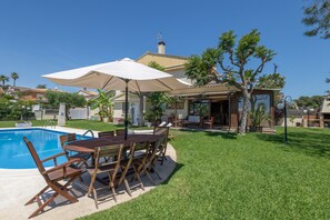 A backyard with a swimming pool, wooden deck, and outdoor furniture. - Holiday Home 'Elegance, Privacy, and Comfort' with Sea View, Private Pool and Wi-Fi (Calafell)
