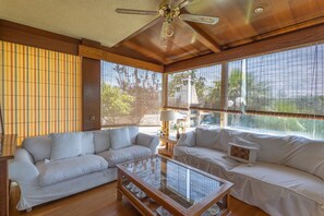 A room with a ceiling fan, two white sofas, a glass coffee table, and large windows with blinds. - Holiday Home 'Elegance, Privacy, and Comfort' with Sea View, Private Pool and Wi-Fi (Calafell)