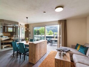 Ein modernes Wohnzimmer mit einer Couch, einem Couchtisch und einem Essbereich mit Stühlen.
