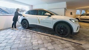 A white SUV parked in a garage with a paved floor and a person standing beside it. - Exclusive vacation apartments with private spa in the Tyrolean Alps (Zellbergeben)
