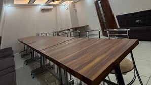 A modern conference room with a long table, chairs, and a ceiling with recessed lighting and a central circular design. - Hotel Kartik (Zirakpur)