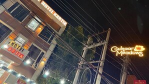 A multi-story building with signage for 'Hotel Artik' and 'Gulnaar Meadows.' - Hotel Kartik (Zirakpur)